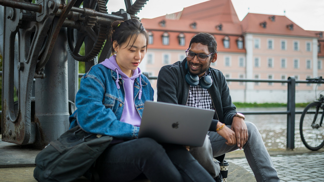 Eine Studentin und ein Student sitzen am Kranen in Bamberg.