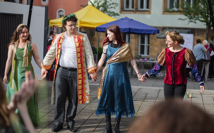 Personen in Verkleidungen führen ein Theaterstück auf.