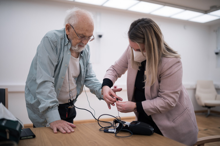 BamLiD-Mitarbeiterin Isabelle Lindner stattet einen Probanden testweise mit einem tragbaren EKG-Gerät aus.