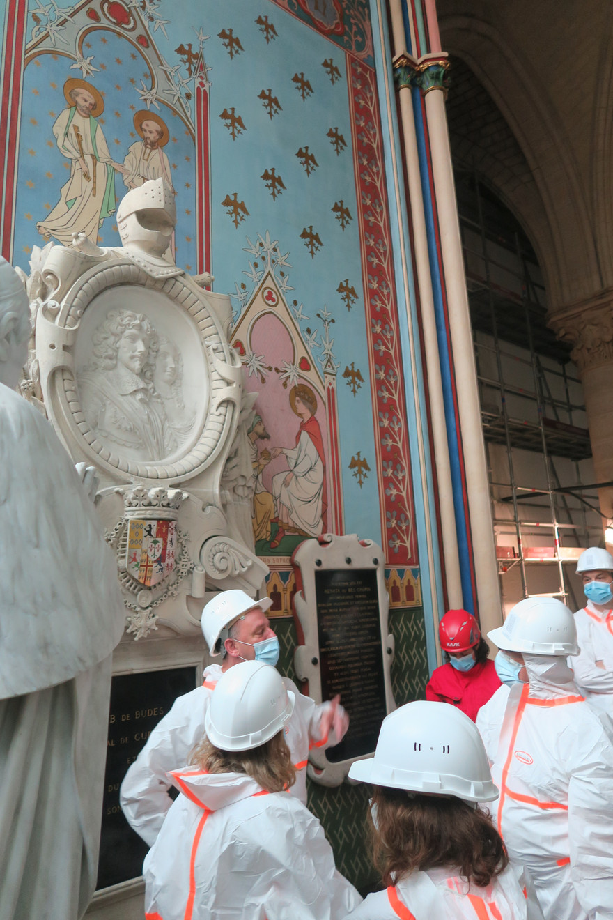 Eine Gruppe von Forschenden in weißen Schutzanzügen stehen in der Kirche Notre-Dame.
