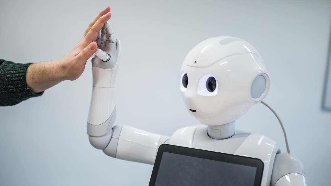 Ein Roboter gibt einem Menschen einen Handschlag.