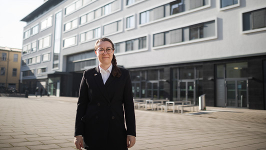 Antidiskriminierungsbeauftragte Cindy Strömel-Scheder steht vor dem Universitätsgebäude auf der Erba-Insel