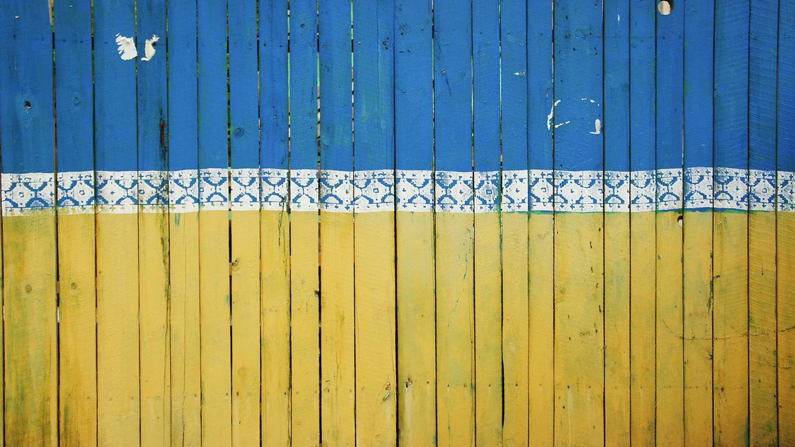 Zaun in blau-gelber Farbe