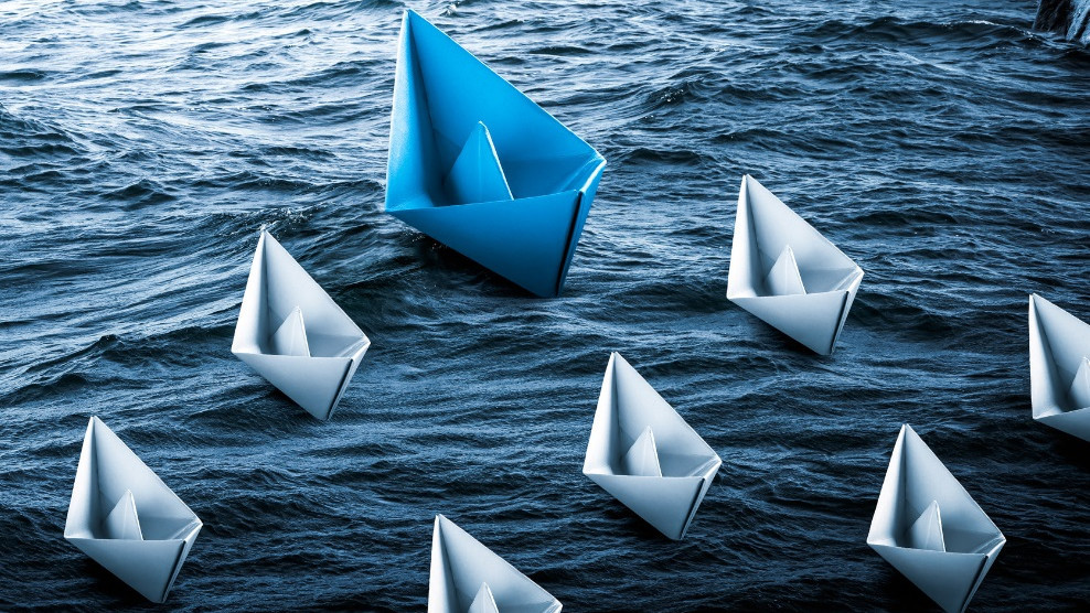 Papierschiffchen schwimmen auf Wasser