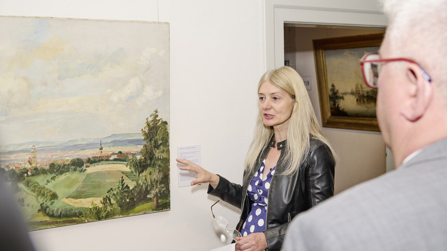 Kristin Knebel, Direktorin der Bamberger Museen, steht vor einem Landschaftsgemälde von Fritz Bayerlein