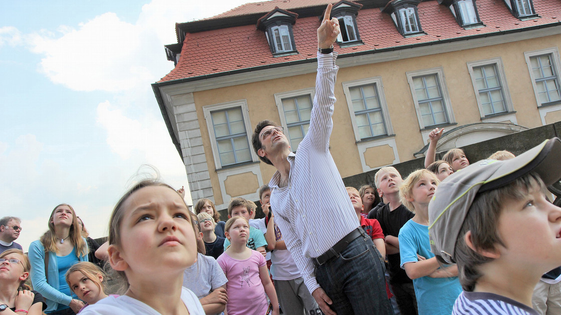 Kinder lauschen Professor Dr. Stefan Breitling, der sie auf verschiedene Erneuerungen am Bamberger Dom aufmerksam macht.