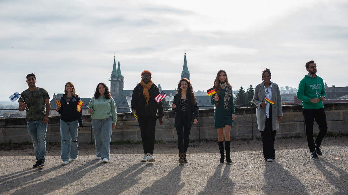 Ausländische Studierende stehen vor der Bamberger Skyline