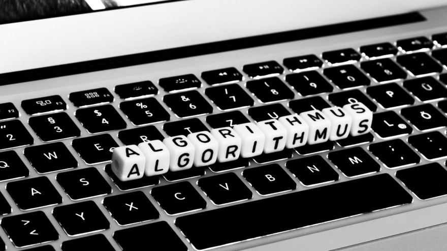 Tastatur mit Würfeln, die das Wort "Algorithmus" abbilden.