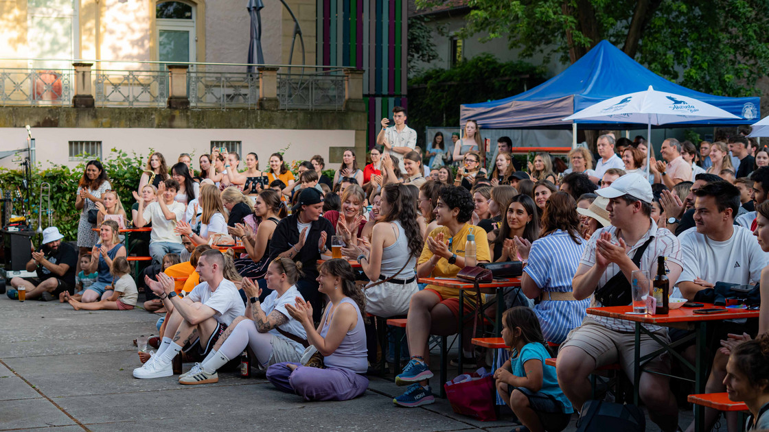 Zahlreiche Menschen sitzen vor der Bühne beim uni.fest