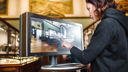 Eine Frau benutzt den Monitor als virtuellen Museumsführer.