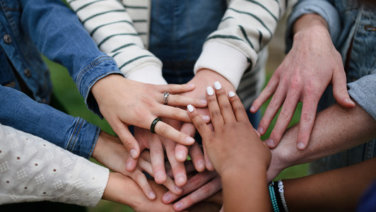 Close-up of diverse group of friends stacking their hands together in circle, Friendship and lifestyle concepts