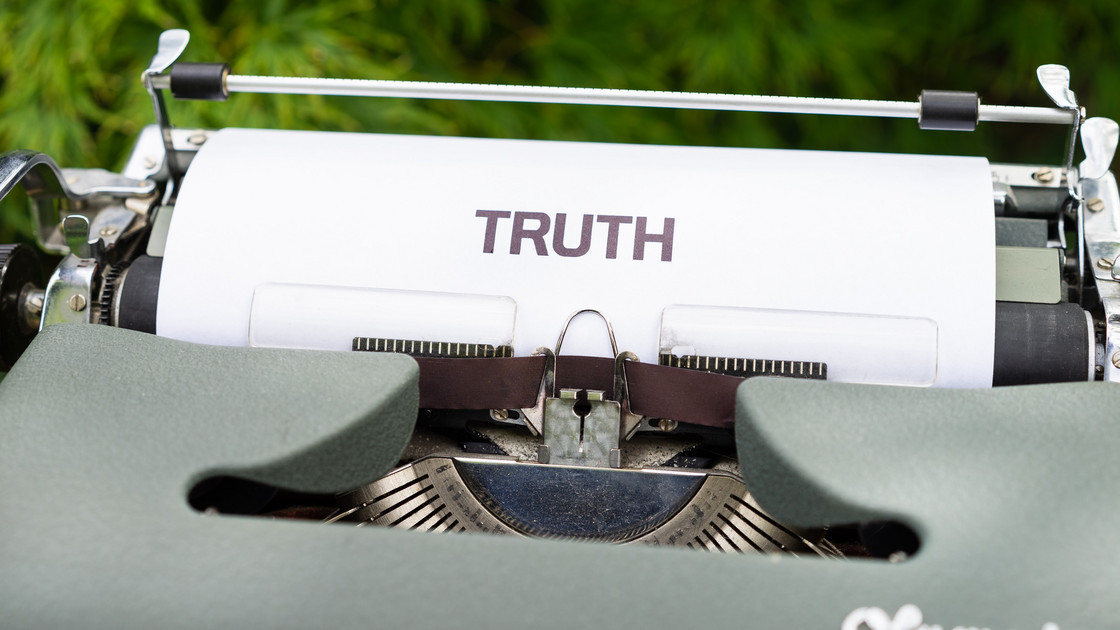 Eine Schreibmaschine in der ein Blatt mit der dem Wort "TRUTH" seht, auf deutsch "Wahrheit".