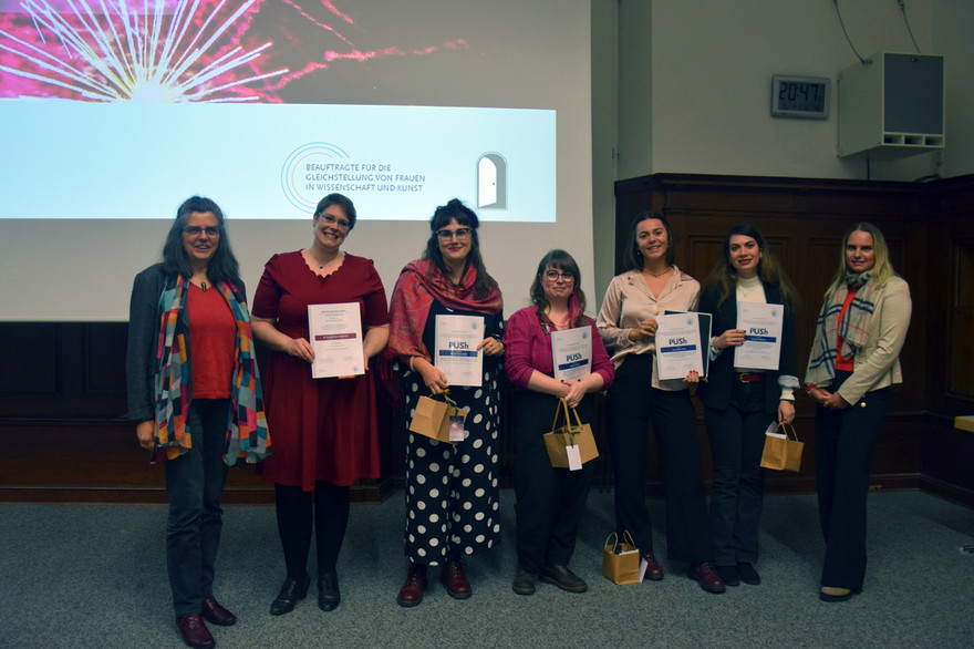 Vizepräsidentin für Diversität und Internationales Sabine Vogt (l.) und Universitätsgleichstellungsbeauftragte in der Wissenschaft Silvia Annen (r.) mit den Preisträgerinnen (v.l.n.r.) Kerstin-Anja Münderlein, Theresa Sennefelder, Natalie Daßler, Ayşha-Sophie Sıdra und Shamim Miroliaei.