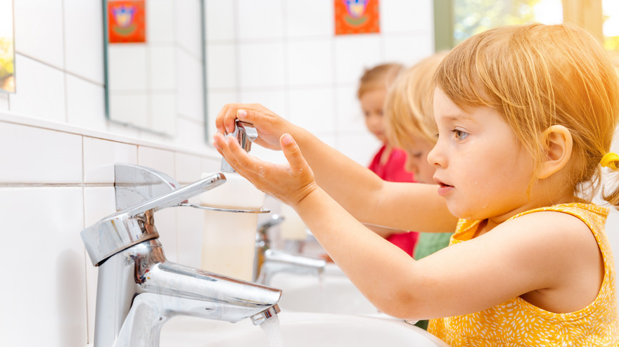 Kinder im Kindergarten waschen die Hände.
