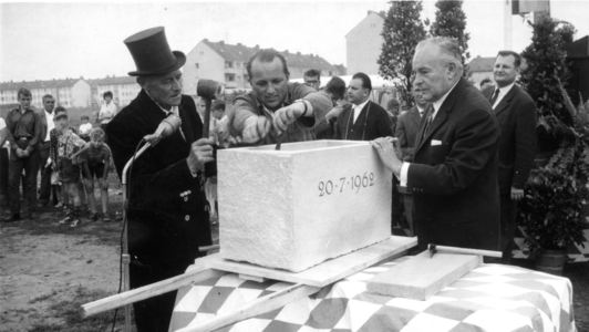 Zwei Männer vollziehen die offizielle Grundsteinlegung des Bamberger Universitätsgebäudes in der Feldkirchenstraße
