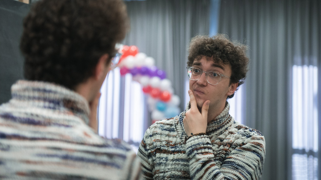 Der Student Sebastian Burkard schaut nachdenklich in den Spiegel