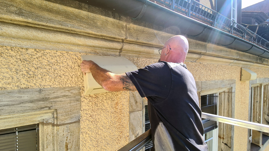 Nistkästen werden an der Fassade angebracht.