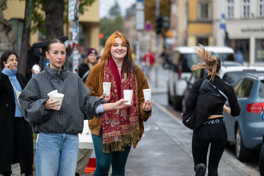 Zwei Frauen geben Wasser an die Laufenden aus.